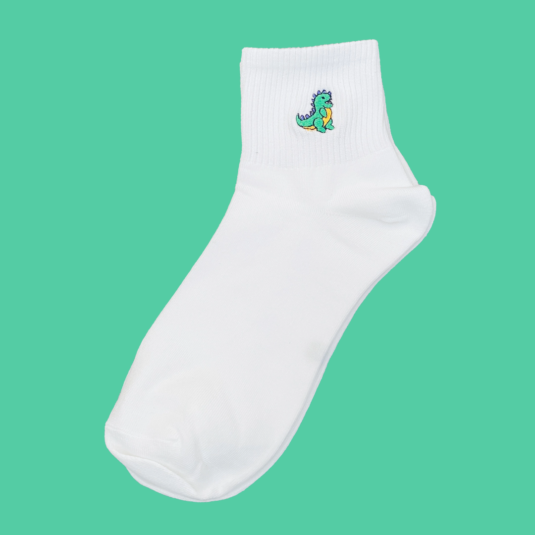 White sock with a green dinosaur design on a teal background