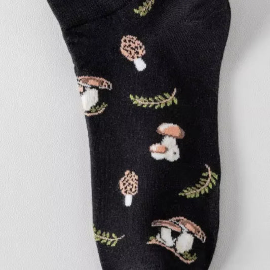 Black sock with cartoon mushroom and rabbit design on a white background