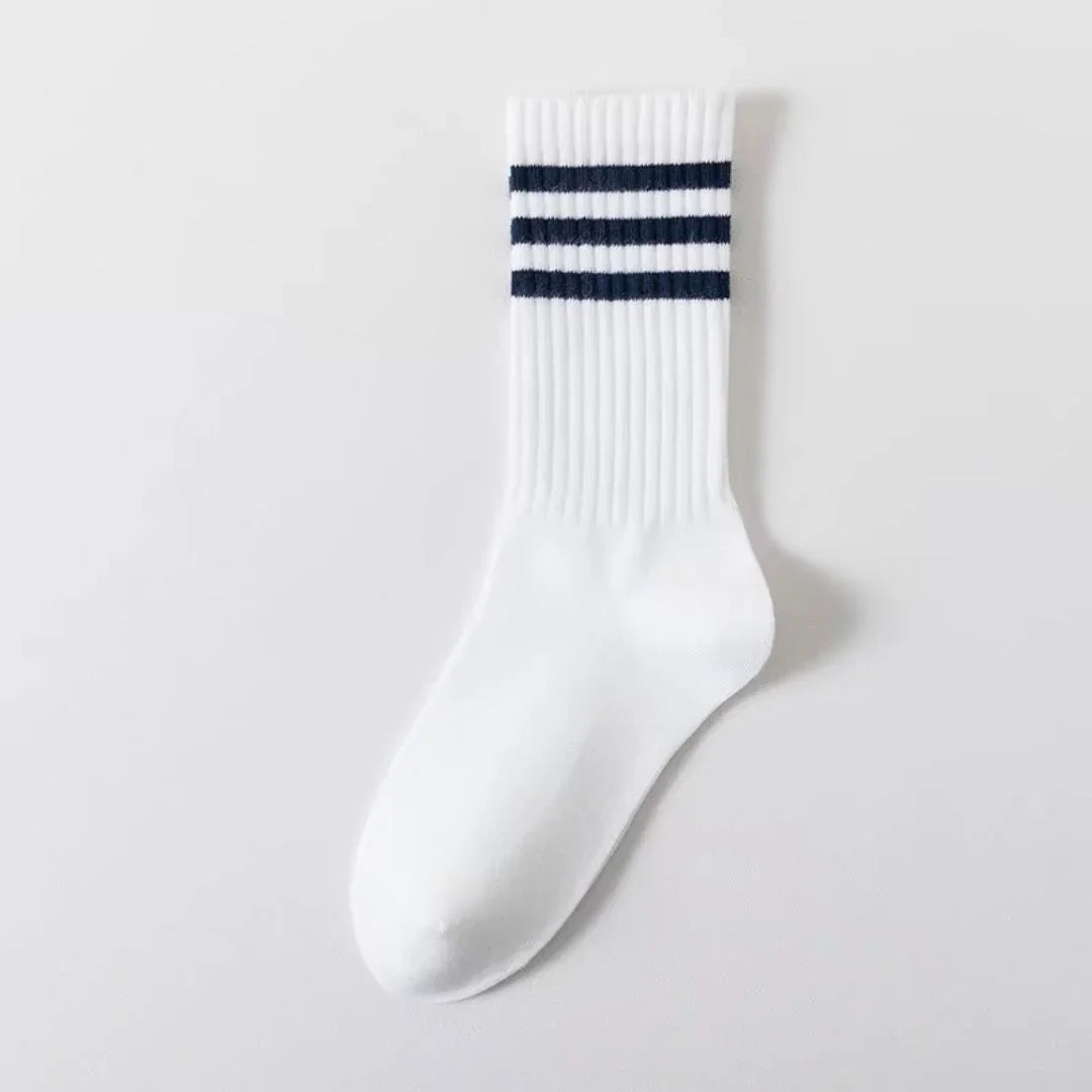 White crew sock with three navy blue stripes on ribbed cuff, displayed on plain white background