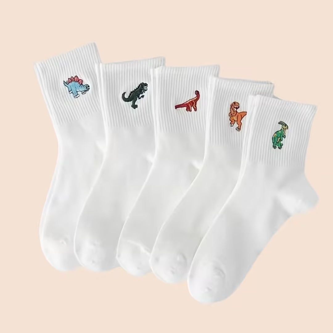 Set of five white socks with embroidered dinosaur designs on a beige background