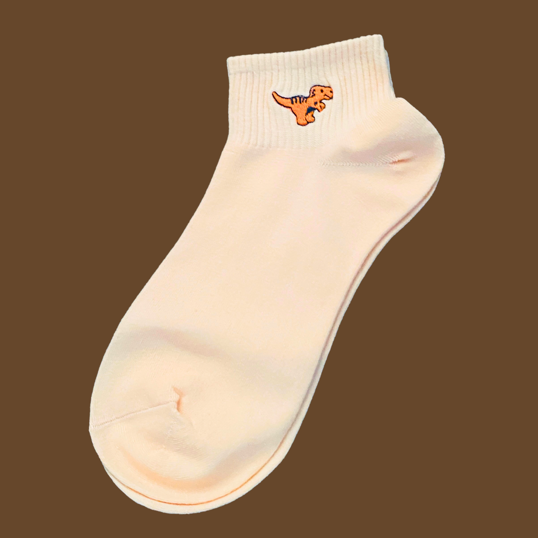 White ankle sock with a small dinosaur design on a brown background