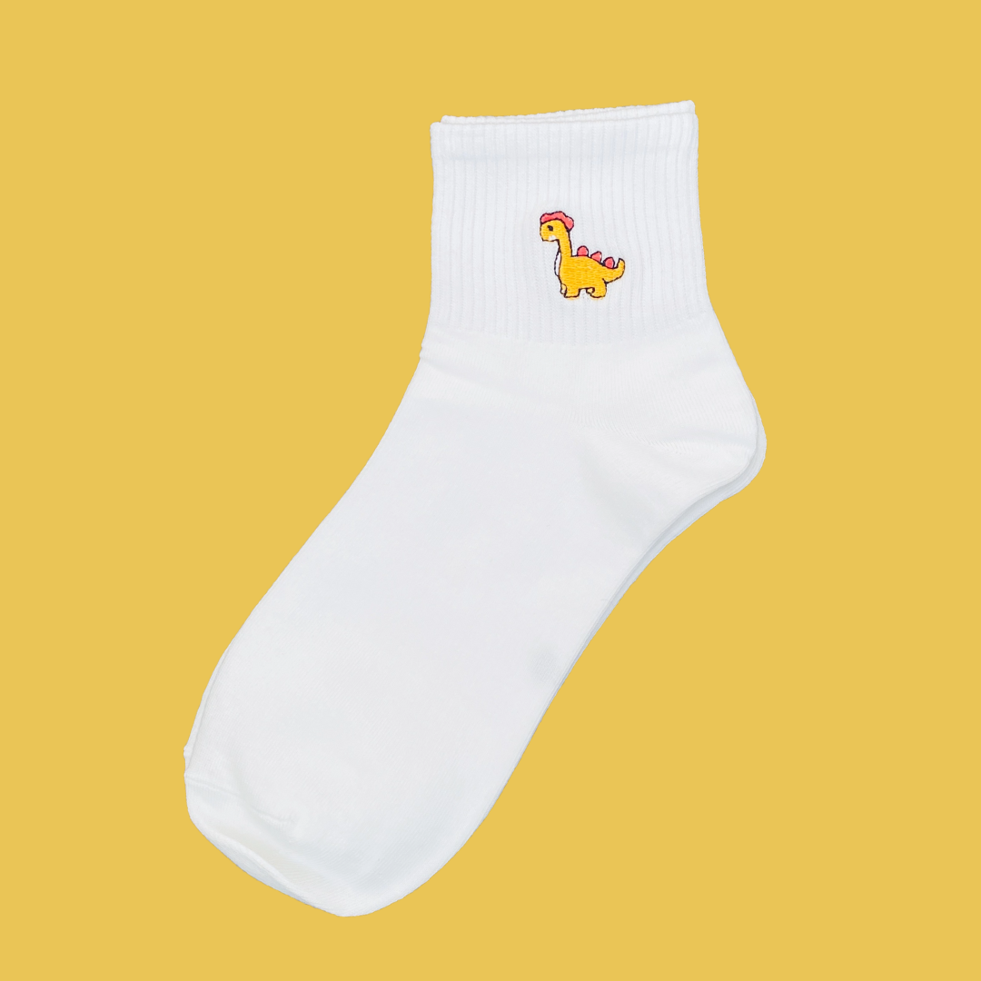 White sock with a colorful dinosaur design on a yellow background