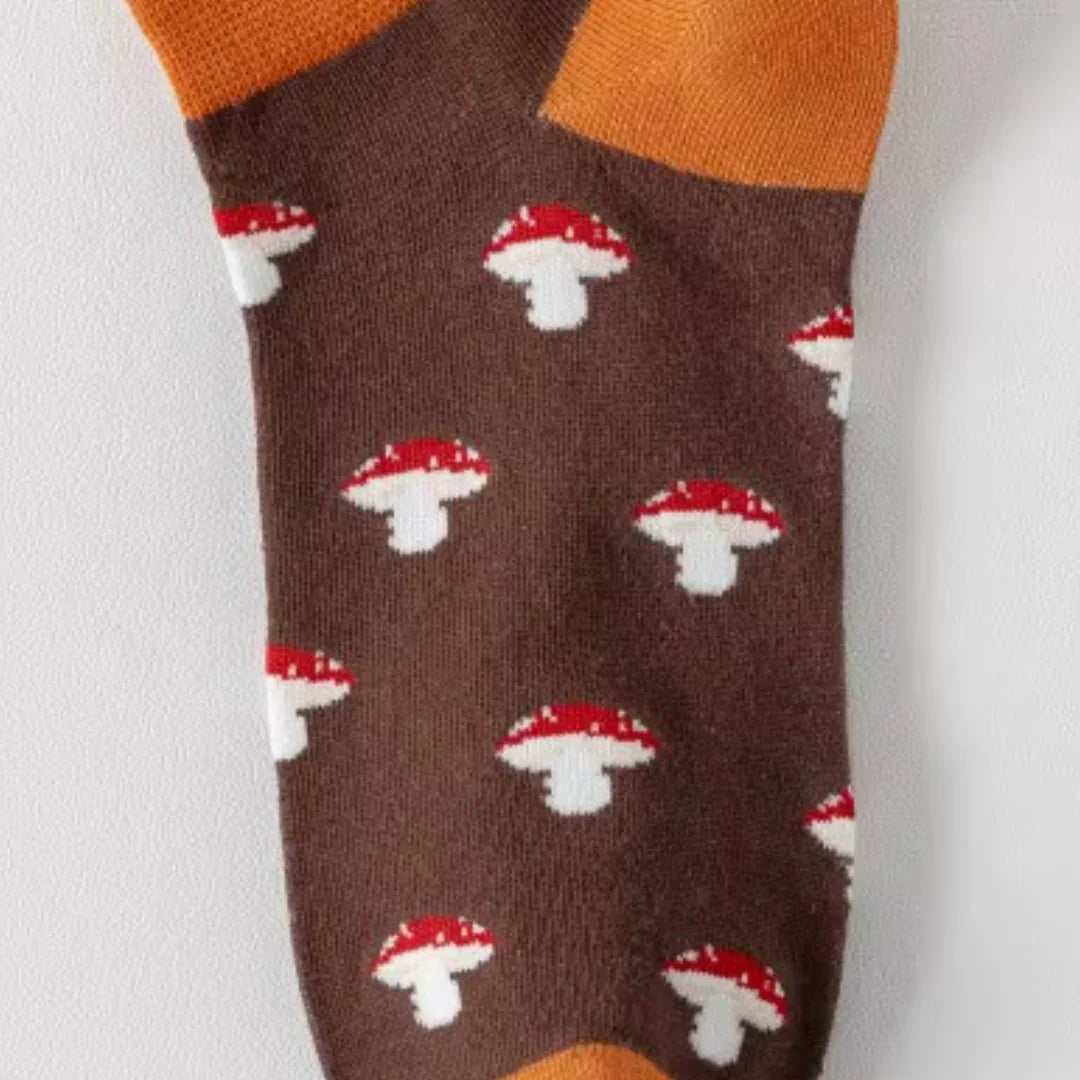 Brown sock with red and white mushroom pattern on a light gray background