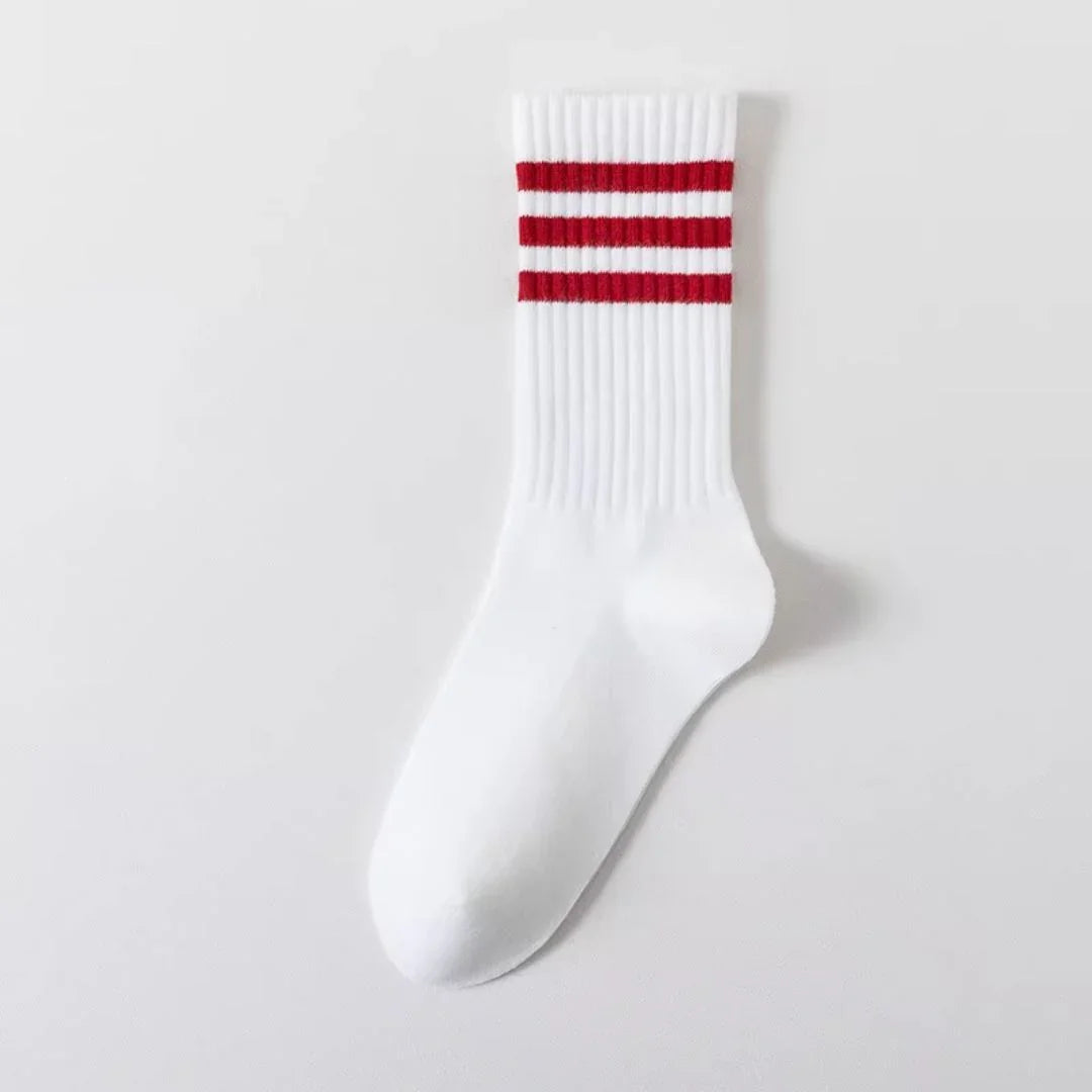 White sporty crew sock with three red horizontal stripes on ribbed cuff, isolated on white background