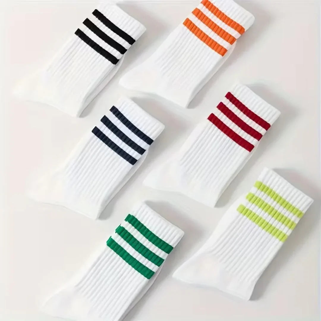 Set of white socks with colorful stripes on a light background